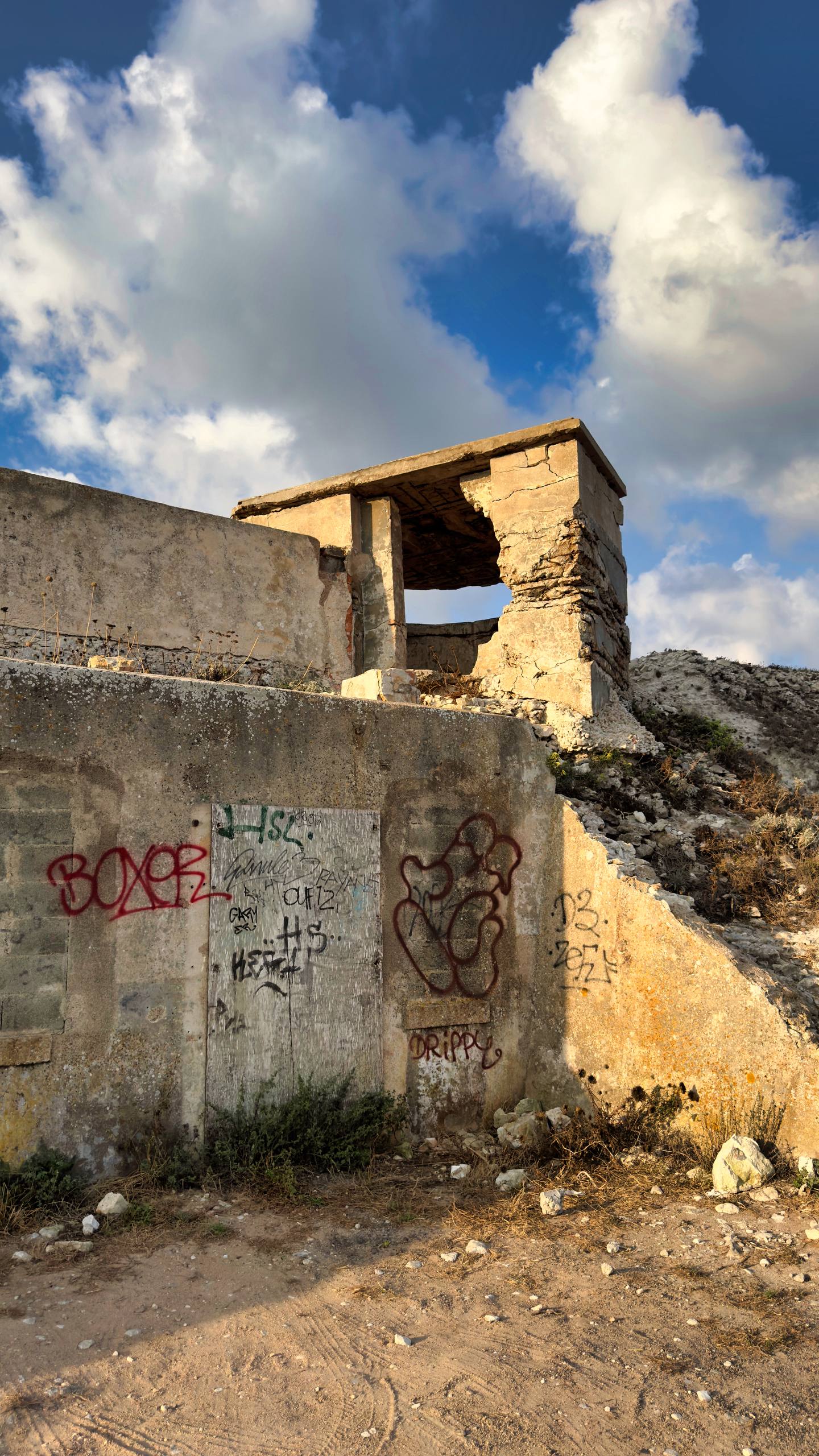 An abandoned WWII bunker covered in colourful graffiti tags