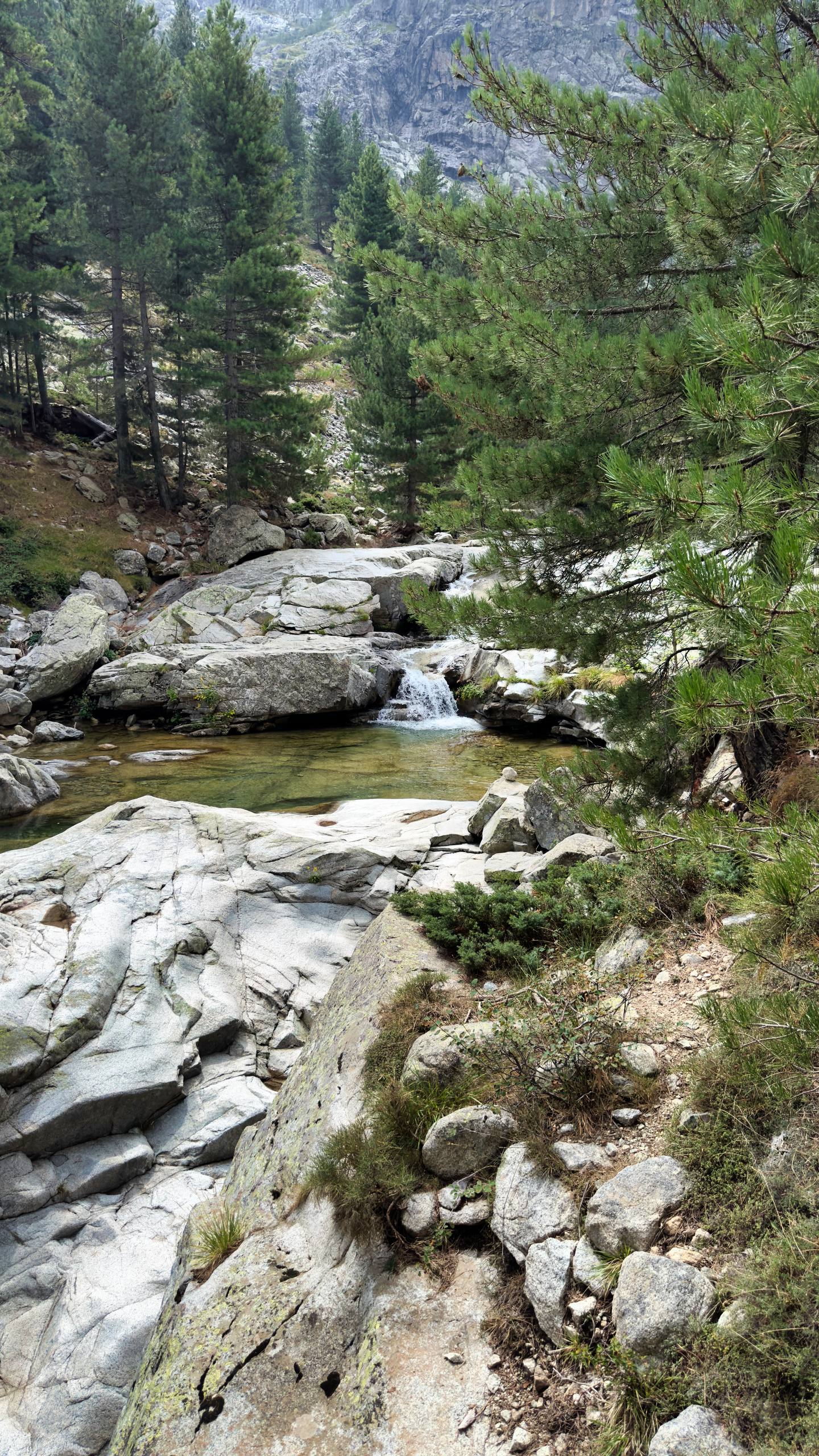 A clear mountain stream tumbling over polished white granite boulders